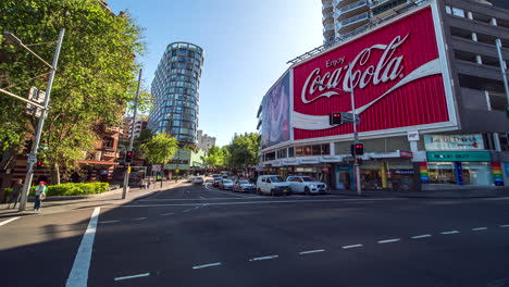 Timelapse-of-vehicles-driving-past-large-Coca-Cola-sign,-Sydney,-Australia
