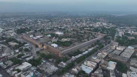 Aerial-drone-rotating-shot-over-residential-houses-in-Umerkot-city,-Tharparkar,-Pakistan-during-evening-time