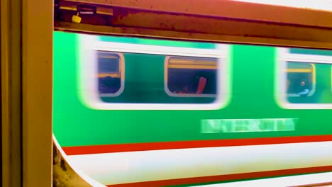 Blick-Auf-Einen-Vorbeifahrenden-Zug-Durch-Ein-Anderes-Zugfenster-In-Bangladesch