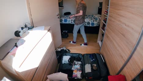 Time-lapse-of-young-female-packing-a-suitcase-for-travel-in-the-room
