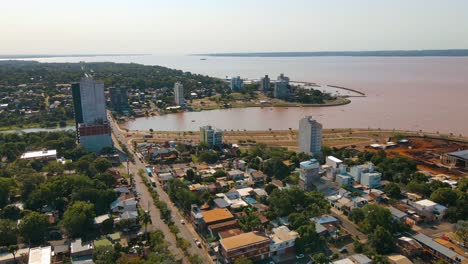 Aerial-view-capturing-Bahia-del-Brete-in-Posadas-city,-featuring-the-beautiful-Paraná-River-in-the-backdrop