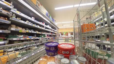 POV-supermarket-shopping-cart-walking-down-butcher-grocery-products-aisle