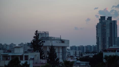 Tag-zu-Nacht-Zeitraffer,-Wunderschöner-Bunter-Sonnenuntergangshimmel-über-Der-Stadt-Tel-Aviv,-Israel,-Naher-Osten,-Aufnahme-Vom-Dach-Zur-Goldenen-Stunde,-Rohe-Töne,-Sony-4K-Video