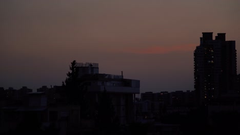 Einschalten-Der-Lichter-Eines-Gebäudes,-Wunderschöner-Bunter-Sonnenuntergangshimmel-über-Der-Stadt-Tel-Aviv,-Israel,-Naher-Osten,-Rohe-Töne,-Sony-4K-Zeitraffervideo