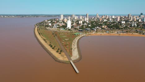 Scenic-aerial-view-of-Bahia-do-Brete-in-Posadas,-Argentina,-framed-by-the-majestic-waters-of-the-Paraná-River