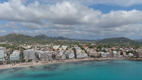 Mallorca:-Aerial-View-Of-Resort-Town-Son-Servera-On-Majorca-Island,-Spain,-Europe-|-City-and-Mountainside-Follow