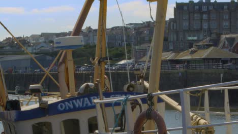 Padstow-fishing-boat-moored-up-on-dock-amongst-shop-front-Close-up