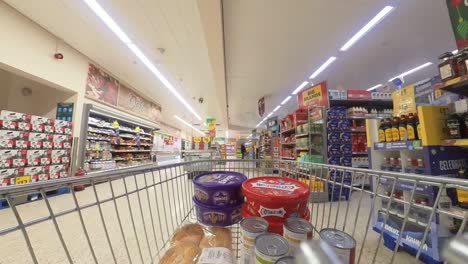 POV-supermarket-shopping-cart-walking-down-deli-grocery-products-aisle