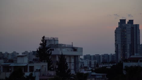 Day-to-night-time-lapse,-beautiful-colorful-sunset-sky-above-Tel-Aviv-city,-Israel-Middle-East,-Raw-tones,-Sony-4K-video