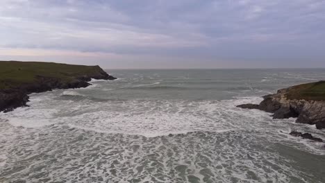 Rising-drone-shot-of-Cornwall-Polly-Joke-coastline-sea-and-rocks-with-distant-horizon
