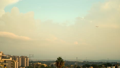 Una-Hermosa-Foto-De-Un-Avión-Volando-Al-Atardecer,-Fue-Tomada-Desde-El-Techo,-Israel-Tel-Aviv,-Medio-Oriente,-Coloridas-Nubes-De-Surf,-Hora-Dorada,-Paisaje-Urbano,-Video-Sony-4k