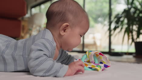 Teething-baby-playing-with-toys-on-tummy-time