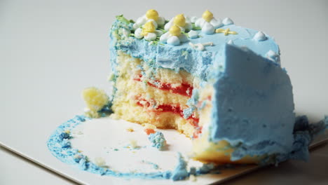Small-round-cake-with-blue-colored-icing-sliced-by-a-fork