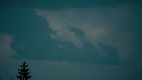 Un-Lapso-De-Tiempo-Escénico-De-Nubes-Deslizantes,-Cielo-Azul-Oscuro,-Clima-Tormentoso,-Medio-Oriente-Tel-Aviv,-Israel,-árbol-En-Movimiento,-Video-Sony-4k