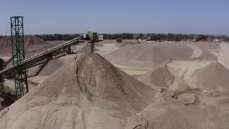 Ein-Großer,-Mit-Sand-Beladener-LKW-Fährt-Auf-Die-Baustelle-Zu,-Luftaufnahmen-Des-LKW-Neben-Der-Baustelle-Und-Materialien