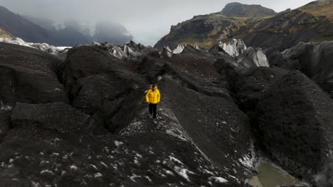 Svinafellsjokull-Glacier,-Iceland---A-Man-Trekking-Over-a-Glacier---Aerial-Pullback