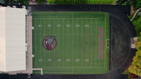 Aerial-capture-of-a-Chicago-football-field,-poised-for-play-with-clear-markings-and-the-'Wolfpack'-logo-at-midfield