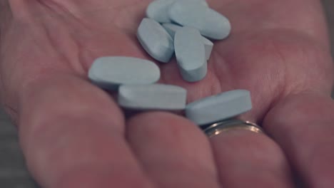 older-hand-of-of-a-senior-citizen-holds-pills-for-prescription-medication