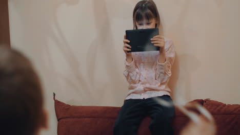 Girl-with-pad-taking-video-of-brother-having-fun