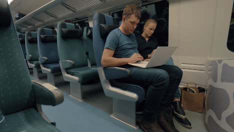 Commuters-with-laptop-and-cell-in-train