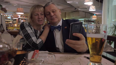 Senior-family-couple-taking-selfie-in-restaurant