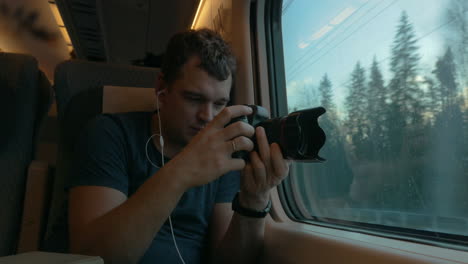 Man-stocker-in-train-listening-to-music-and-making-footage