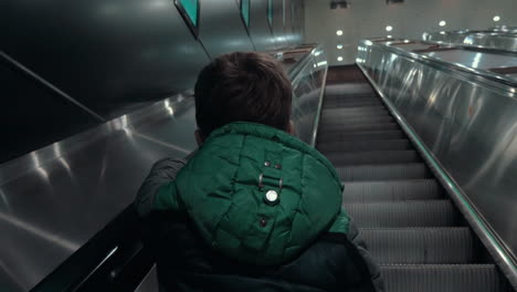 Boy-moving-up-on-escalator-in-subway