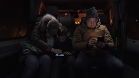 Three-passengers-using-mobiles-in-minibus