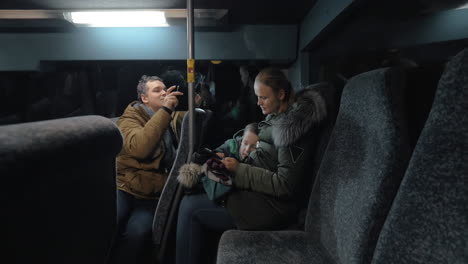 Mom-and-son-using-mobile-in-the-bus-father-taking-video-of-them