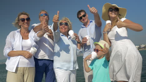 Familia-Feliz-Bebiendo-Té-Y-Mostrando-Los-Pulgares-Hacia-Arriba-Al-Aire-Libre