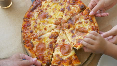 People-taking-slices-of-pizza