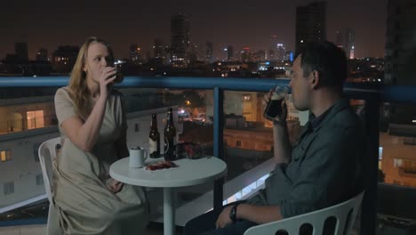 Young-couple-relaxing-and-having-drinks-in-rooftop-cafe-of-night-Tel-Aviv