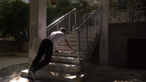 Man-doing-push-ups-at-the-outdoor-staircase