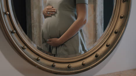 Mujer-Embarazada-Tocando-El-Vientre-Reflejo-De-Espejo