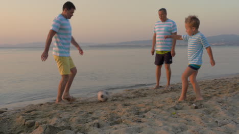 Männer-Aus-Drei-Generationen-Spielen-Fußball-Am-Strand