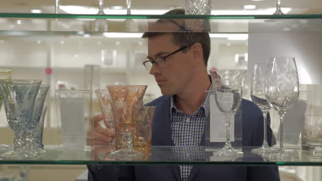 Man-looking-over-glassware-in-the-store
