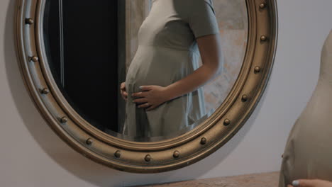 Schwangere-Frau-Blickt-In-Den-Spiegel-Und-Streichelt-Den-Bauch