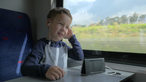 Boy-video-chatting-in-train-using-cell-and-hands-free-set