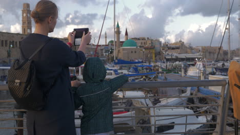 Woman-with-son-taking-photos-when-visiting-Acre-port-Israel
