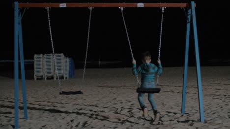 Niño-Balanceándose-Solo-En-La-Playa-Por-La-Noche