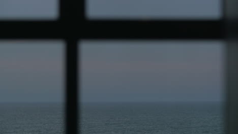 Looking-at-evening-seascape-through-the-window
