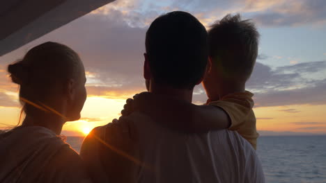 Parents-with-child-looking-at-sunset-and-taking-selfie