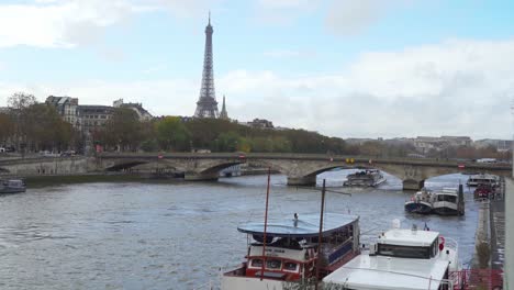 Ferries-Cross-La-Seine-River-in-Paris-with-Eiffel-Tower-in-Distance
