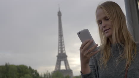Woman-using-mobile-and-taking-shot-of-Eiffel-Tower