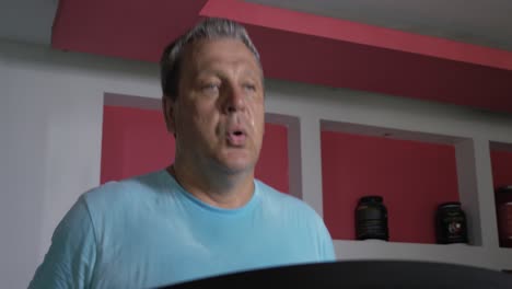 Full-adult-male-runs-on-a-treadmill