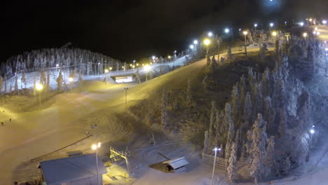 Flying-over-ski-slopes-and-working-lift-at-night