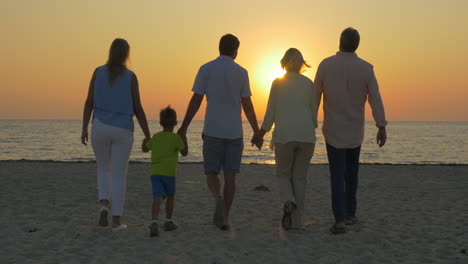 Family-looking-at-golden-sunset-over-the-sea