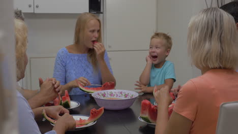Family-with-child-eating-watermelon-in-the-kitchen