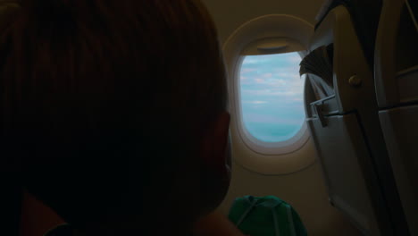 Niño-Mirando-Por-El-Iluminador-En-Avión