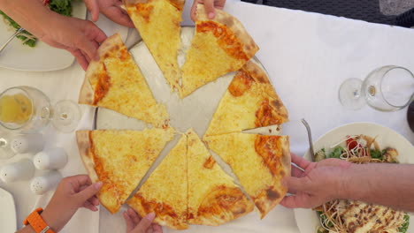 People-taking-slices-of-cheese-pizza-served-in-cafe